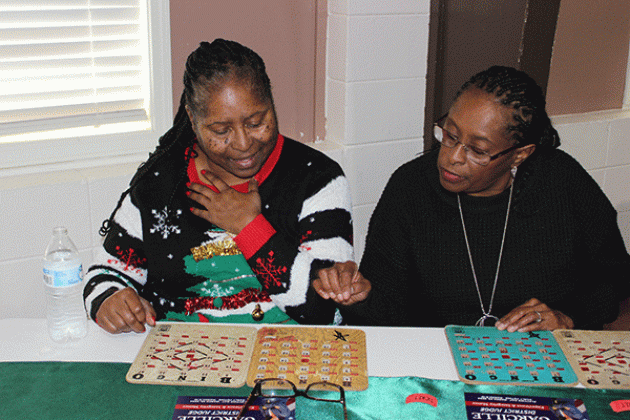 Daphney Victoria, left, and Sharlan Williams play bingo.